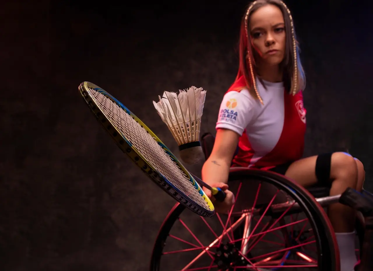Badmintonspiller i kørestol med ketcher og fjerbold